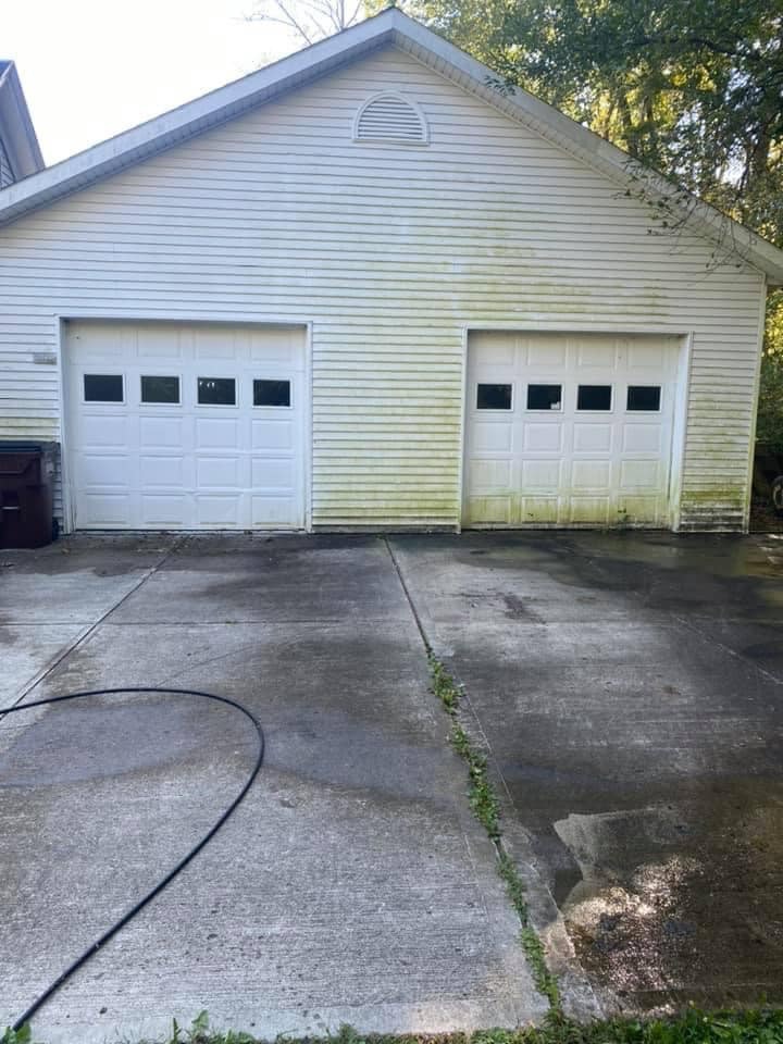 Detached garage before — yellow-green algae streaks on white vinyl siding